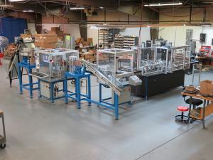 Fully automatic multi-machine assembly system with accumulators, box erector and final packaging